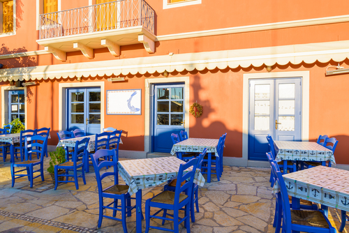 Blue,Chairs,With,Tables,In,Front,Of,Traditional,Greek,Tavern