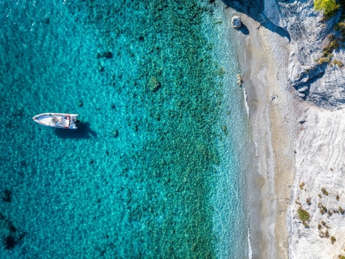 Aerial,View,Of,A,Boat,Anchored,At,The,Beautiful,Coast